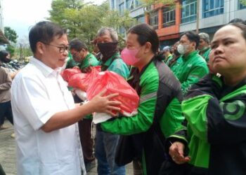 Anggota DPR RI dr Sofyan Tan secara simbolis menyerahkan paket sembako kepada salahsatu driver ojek online di Rumah Aspirasi dr Sofyan Tan, Kompleks CBD Polonia Medan, Kamis (19/01/2023).(seputarsumut/Asiong)