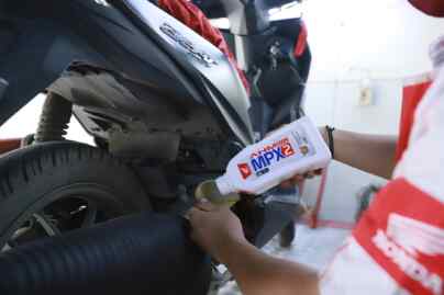 Foto: Teknisi AHASS melakukan penggantian pelumas sepeda motor Honda menggunakan AHM OIL MPX2 dengan ukuran 0,65L.(Ist)