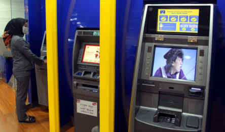 Nasabah bertransaksi di mesin ATM.