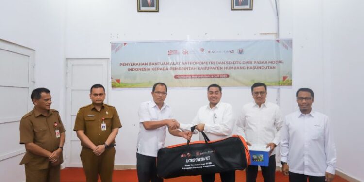 Kepala Satuan Pemeriksa Internal KSEI Gusrinaldi Akhyar, secara simbolis menyerahkan bantuan berupa 90 unit alat antropometri dan 100 unit SDIDTK kepada Bupati Kabupaten Humbang Hasundutan Dosmar Banjarnahor.(Dok:BEI Sumut)