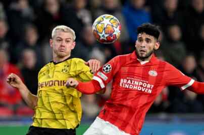 Foto: Bek Dortmund Julian Ryerson berduel dengan penyerang PSV Ricardo Pepi saat pertandingan leg pertama babak 16 besar Liga Champions.