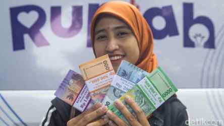 Foto: Warga menunjukan uang hasil penukaran.