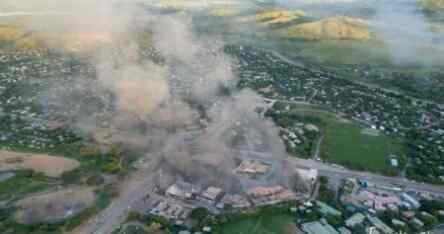 Foto: Asap mengepul dari gedung-gedung yang terbakar di tengah penjarahan dan pembakaran selama aksi protes atas pemotongan gaji polisi di Port Moresby, Papua Nugini.