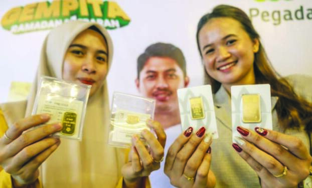 Foto: Karyawati menunjukkan kepingan emas produksi Antam.