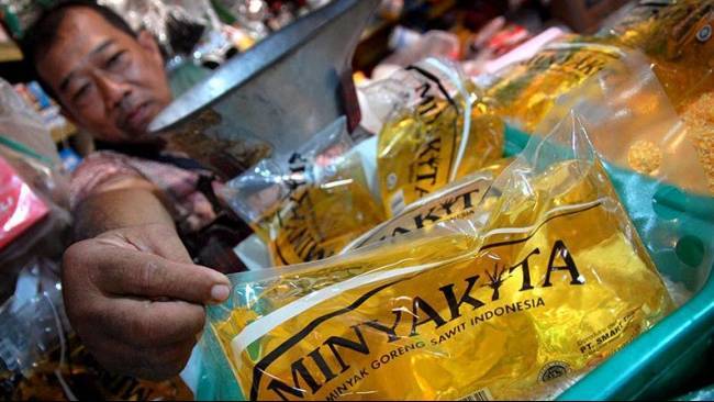Foto: Pedagang menunjukkan minyak goreng rakyat MinyaKita di pasar.