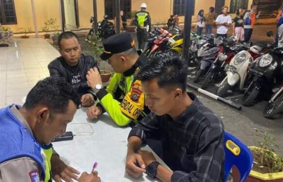 Foto: Petugas menilang pengendara motor yang tak sesuai spesifikasi.