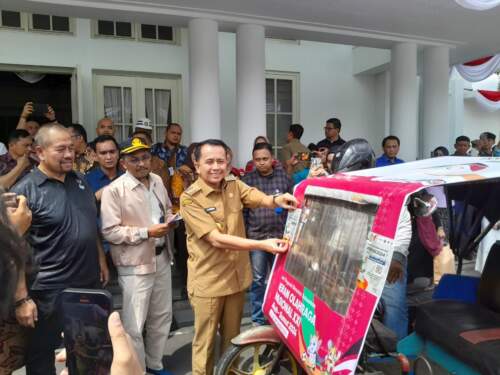 Foto: Pj Gubsu Agus Fatoni memasang stiker sosialisasi PON XXI/2024 Aceh-Sumut di betor.