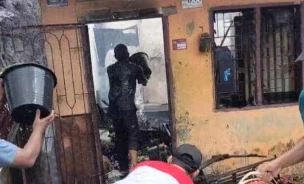 Foto: Warga berusaha memadamkan kobaran api.