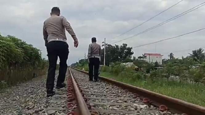 Polisi saat proses evakuasi korban kecelakaan di perlintasan kereta api tanpa palang pintu di persimpangan Desa Brohol, Kecamatan Sei Suka, Kabupaten Batu Bara, Sumatera Utara, Selasa (6/8/2024). (Foto: iNews/Fadli Pelka)