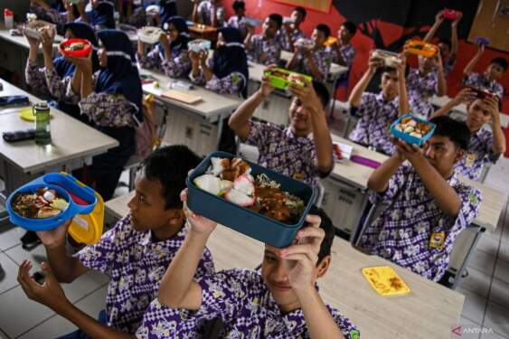 Foto: Sejumlah siswa menunjukkan makanan gratis saat simulasi program makan siang gratis di SMP Negeri 2 Curug, Kabupaten Tangerang, Banten.