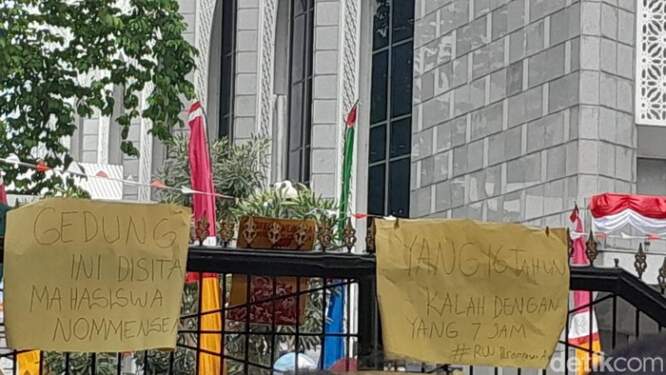 Foto: Poster bertuliskan 'Tolak Dinasti Politik' dan 'Gedung Ini Disita Mahasiswa Nommensen' terpasang di gerbang kantor DPRD Sumut saat terjadi aksi unjuk rasa mahasiswa.