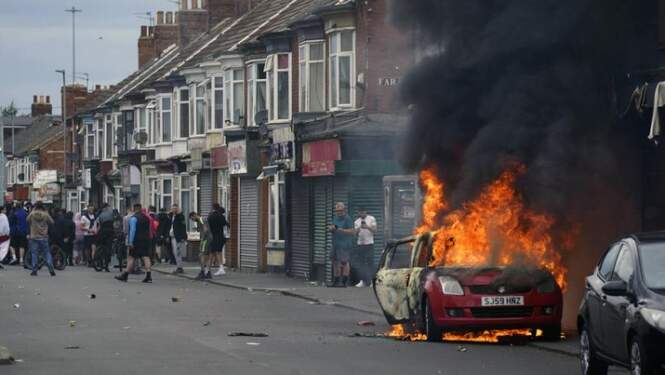 Foto: Sebuah mobil terbakar selama protes antiimigrasi di Middlesbrough, Inggris, Minggu 4 Agustus 2024. (AP/Owen Humphreys)