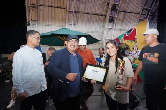 Foto: Kadisdik Provsu Ir Abdul Haris Lubis MSi menyerahkan trophy kepada salah satu perwakilan grup band juara Festival Band Anak Sumut 2024 di Panggung Area PRSU, Medan, Minggu (15/09/2024). (seputarsumut/asril tanjung)