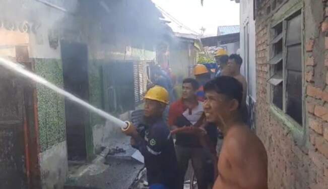 Foto: Petugas memadamkan api di rumah kontrakan yang terbakar di Kisaran.