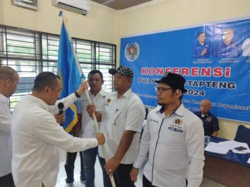 Foto: Ketua PWI Sumut Farianda Putra Sinik menyerahkan pataka kepada Sahat Jason Gultom yang terpilih sebagai Ketua PWI Sibolga-Tapteng periode 2024-2027, Kamis (5/9/2024) di Kantor PWI Sumut.