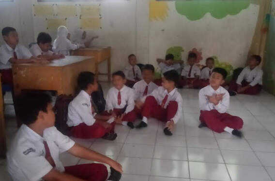 Foto: Siswa duduk di lantai saat belajar.