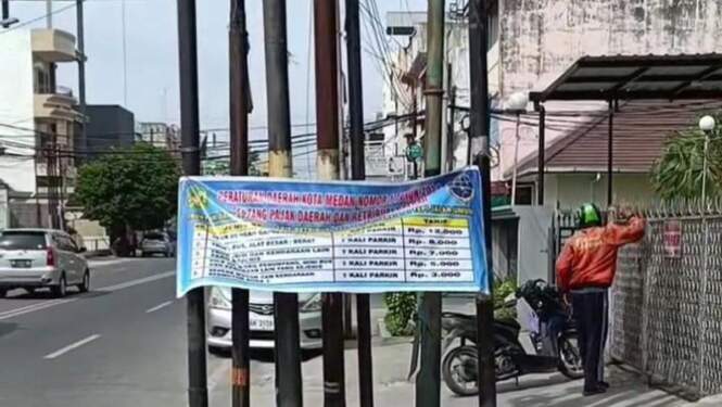 Foto: Spanduk terkait besaran tarif parkir tepi jalan yang baru di Medan.