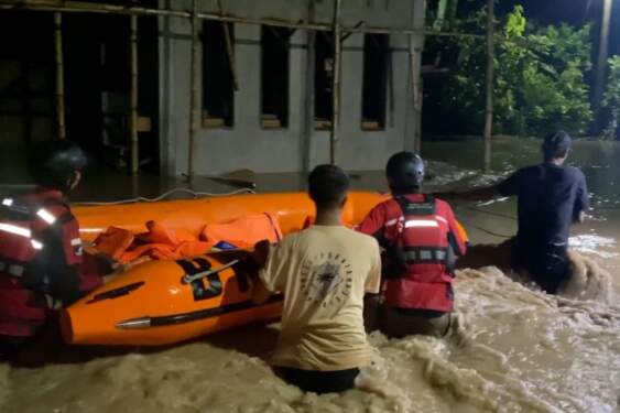 Foto: Warga melintasi banjir di kawasan Desa Jojo, Kecamatan Mutiara, Kabupaten Pidie, Aceh, Jumat (22/11/2024) malam.