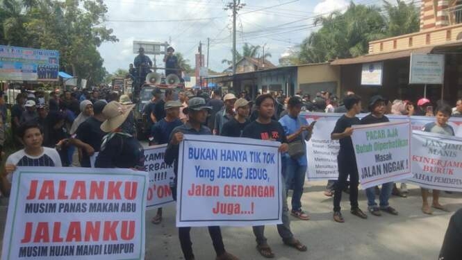 Aksi warga di Asahan ancam blokir akses masuk pintu jalan tol Kisaran saat demo jalan rusak. 