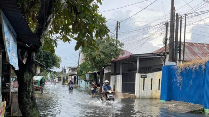 Foto: Kondisi ruas jalan yang terendam banjir di Medan Helvetia.