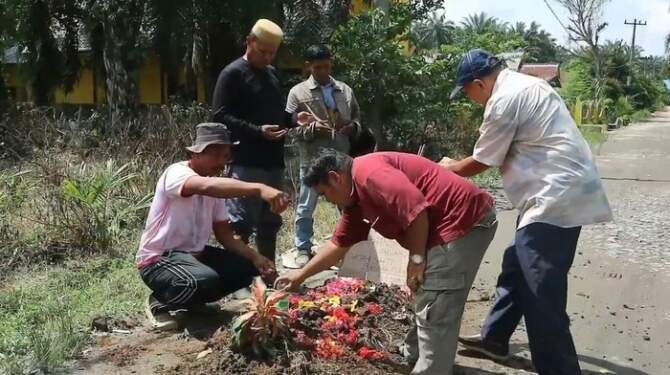 Foto: Warga Desa Gajah Sakti, Kecamatan Bandar Pulau, Kabupaten Asahan, Sumut bangun 'kuburan' di tepi jalan sebagai bentuk protes.