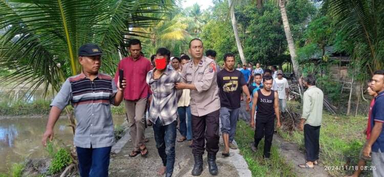 Foto: Wildan tersangka pembacokan ibu kandung saat diamankan warga.
