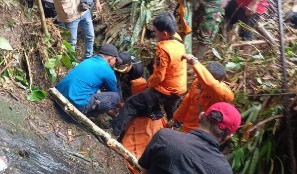 Foto: Petugas saat mengevakuasi jasad korban hanyut di Sungai Bah Sombu.