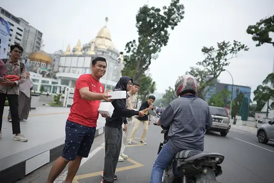 Creator Dipoloop Medan membagikan lebih dari 100 takjil kepada masyarakat yang melintas di Jalan Diponegoro Medan, Kamis (20/3/2025).(Ist)
