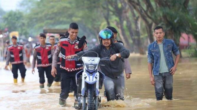 Kendaraan melintasi jalan nasional yang terendam banjir di Alue Bata, Tadu Raya, Nagan Raya, Rabu (5/3/2025).