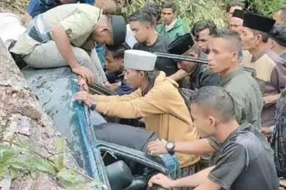 Sejumlah warga berusaha mengevakuasi satu keluarga yang terjebak di dalam mobil tertimpa pohon tumbang jalan lintas Blangkejeren-Kutacane.