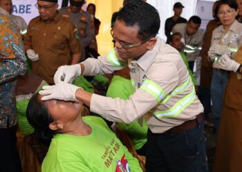 GMO & Deputy Director Operations PT Agincourt Resources, Rahmat Lubis, membuka perban mata Endang Siregar, warga Kelurahan Perkebunan Batang Toru, salah satu pasien Operasi Katarak Gratis Tambang Emas Martabe, Senin (29/9/2025). (Dok: PTAR)