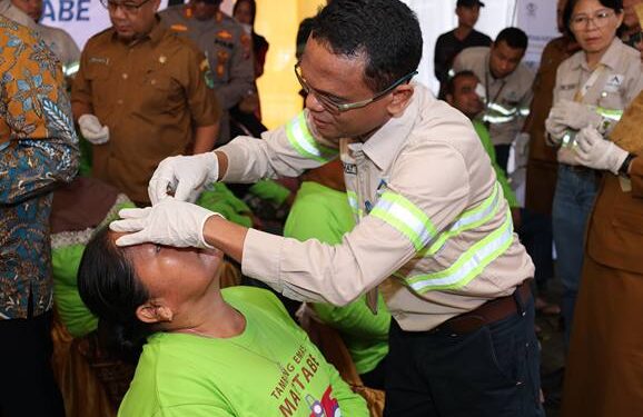 GMO & Deputy Director Operations PT Agincourt Resources, Rahmat Lubis, membuka perban mata Endang Siregar, warga Kelurahan Perkebunan Batang Toru, salah satu pasien Operasi Katarak Gratis Tambang Emas Martabe, Senin (29/9/2025). (Dok: PTAR)