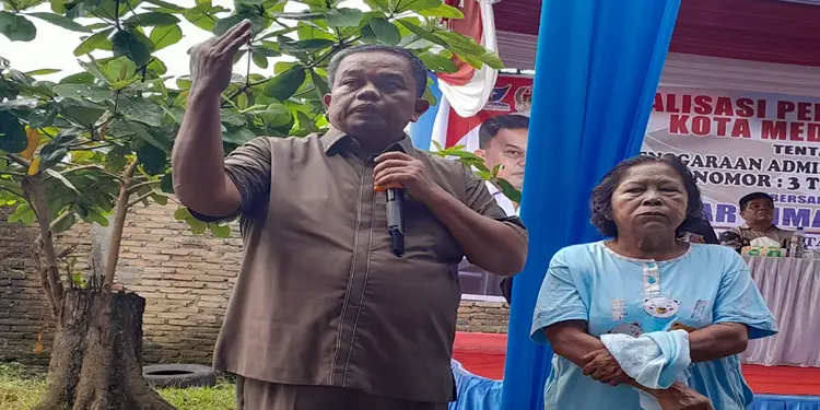 Foto: Anggota DPRD Kota Medan Binsar Simarmata ditemani salah satu warga menyampaikan sambutan saat Sosper di Lapangan Komplek GKPS Simalingkar, Jalan Bunga Rampai 2, Medan Tuntungan, Sabtu (18/7/2026).(Ist)